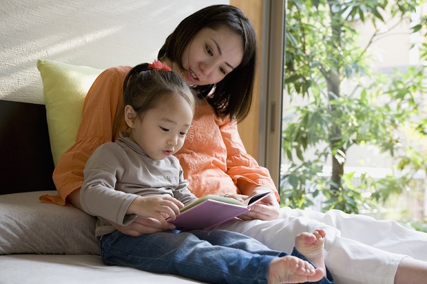 Mother Reading Picture Book for Daughter